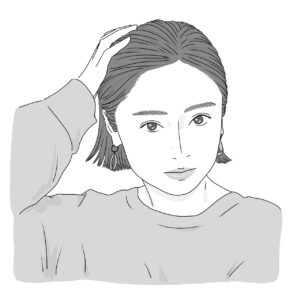 女性が不意に手を頭に当てている様子